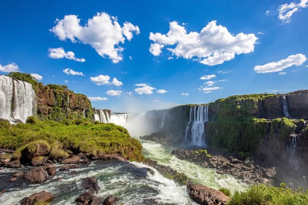 Panorama des chutes d’Iguaçu sous un ciel bleu.